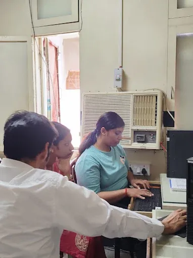 Faculty member helping a student at a lab computer at IPA, Laxmi Nagar